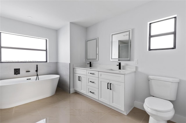 bathroom with a bathtub, toilet, tile walls, and vanity