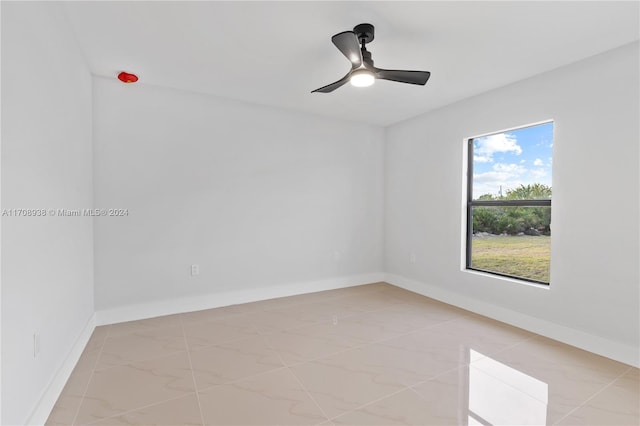 spare room featuring ceiling fan and light tile patterned floors