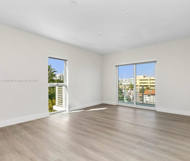 spare room with light hardwood / wood-style floors and a wealth of natural light