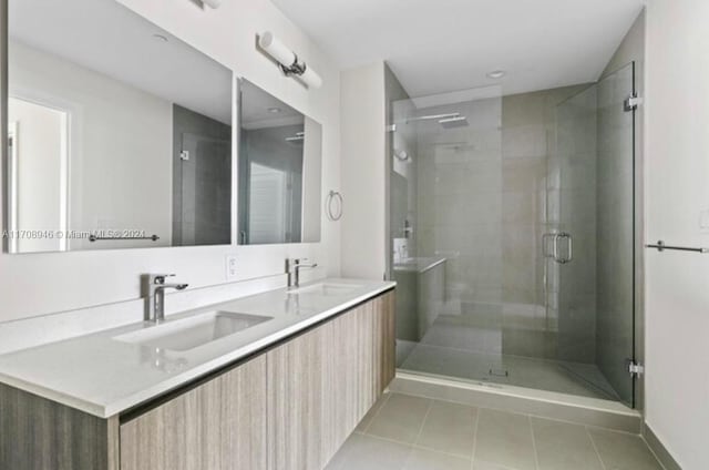 bathroom featuring tile patterned flooring, vanity, and a shower with shower door