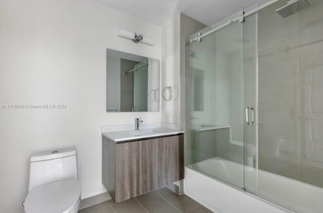 full bathroom featuring tile patterned floors, vanity, toilet, and shower / bath combination with glass door