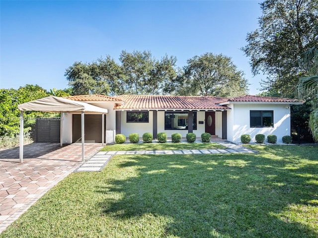 mediterranean / spanish house featuring a front yard, a carport, and covered porch