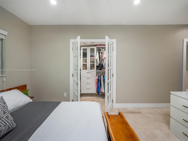 bedroom with light tile patterned flooring, french doors, and a closet