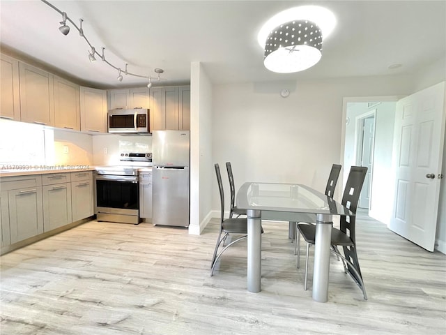 kitchen with gray cabinetry, light hardwood / wood-style flooring, and stainless steel appliances