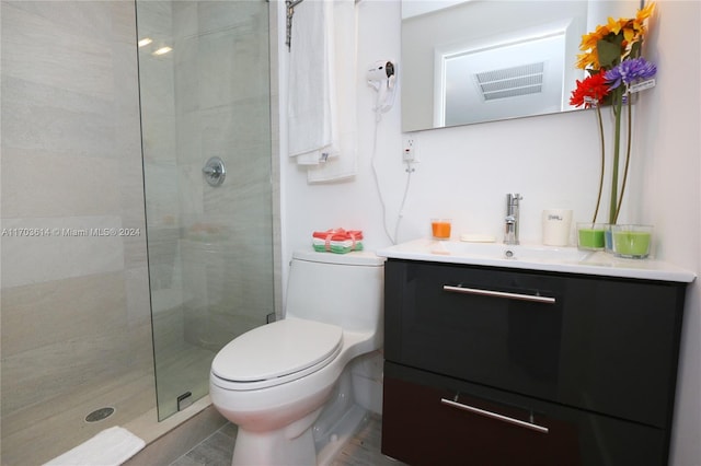 bathroom with vanity, toilet, and a shower with door