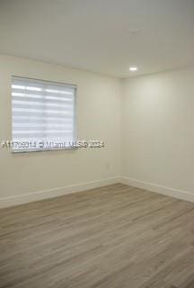 unfurnished room with hardwood / wood-style flooring