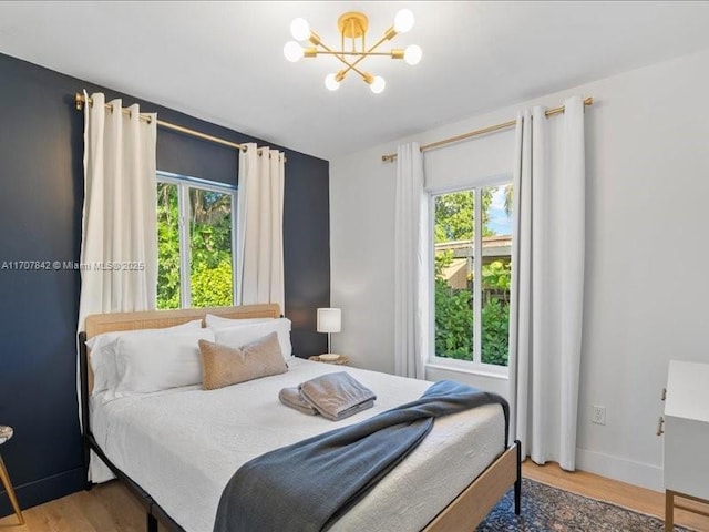 bedroom with hardwood / wood-style floors and a chandelier