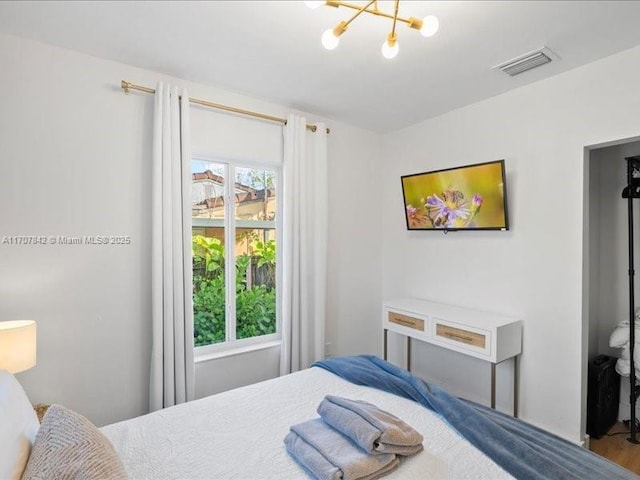 bedroom featuring multiple windows and a notable chandelier