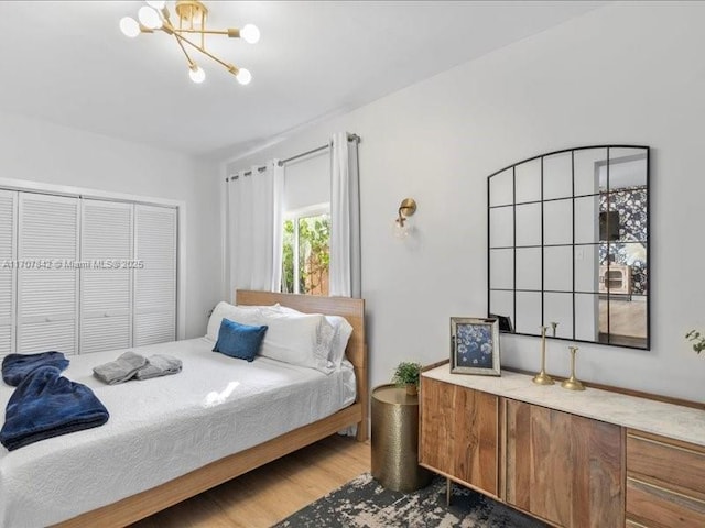 bedroom featuring hardwood / wood-style floors and a notable chandelier