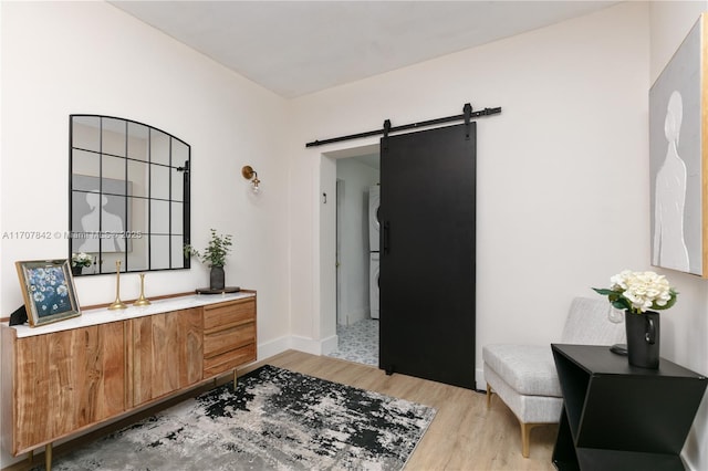 interior space with a barn door and light hardwood / wood-style flooring