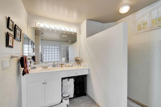 bathroom with tile patterned flooring, vanity, and walk in shower