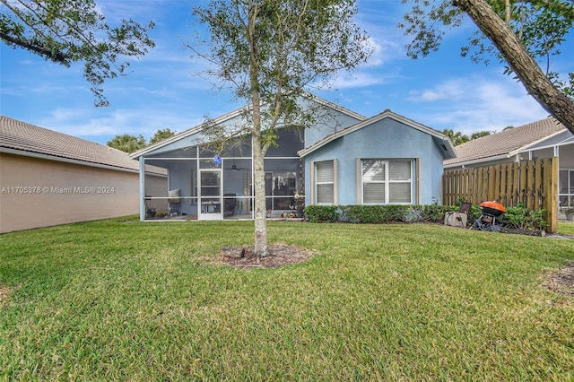 rear view of property with a sunroom and a lawn