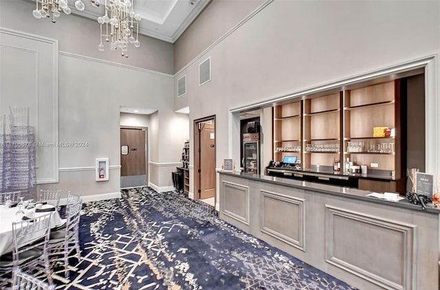 bar featuring a towering ceiling, decorative light fixtures, an inviting chandelier, and crown molding