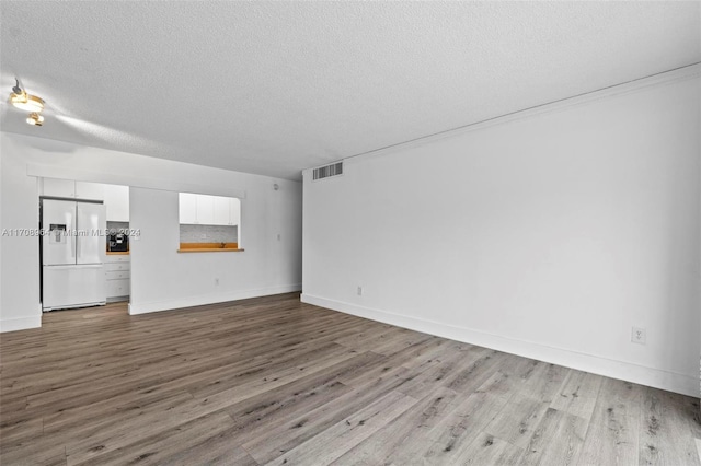 unfurnished living room with hardwood / wood-style flooring and a textured ceiling