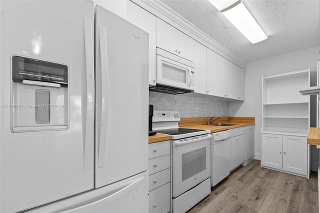 kitchen featuring white appliances, sink, light hardwood / wood-style flooring, butcher block countertops, and white cabinetry