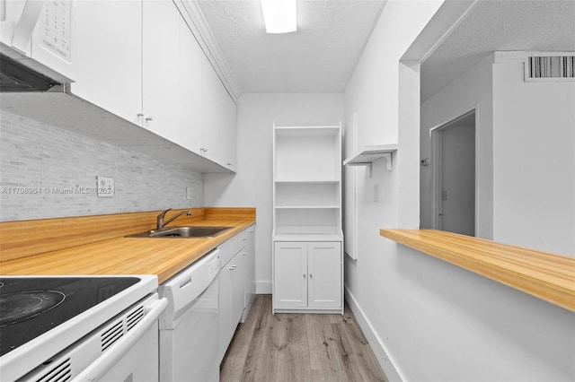 kitchen with decorative backsplash, white appliances, sink, light hardwood / wood-style flooring, and white cabinets