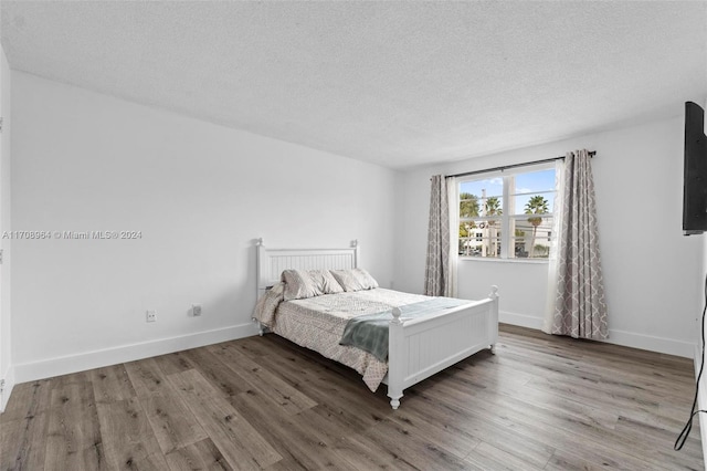 bedroom with wood-type flooring and a textured ceiling