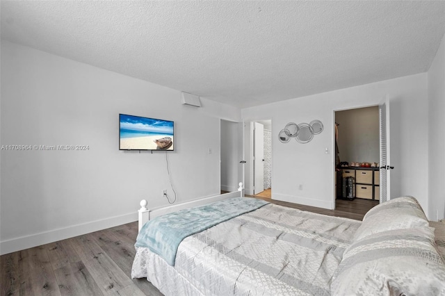 bedroom with a textured ceiling and hardwood / wood-style flooring