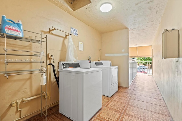 laundry room with a textured ceiling and washer and clothes dryer