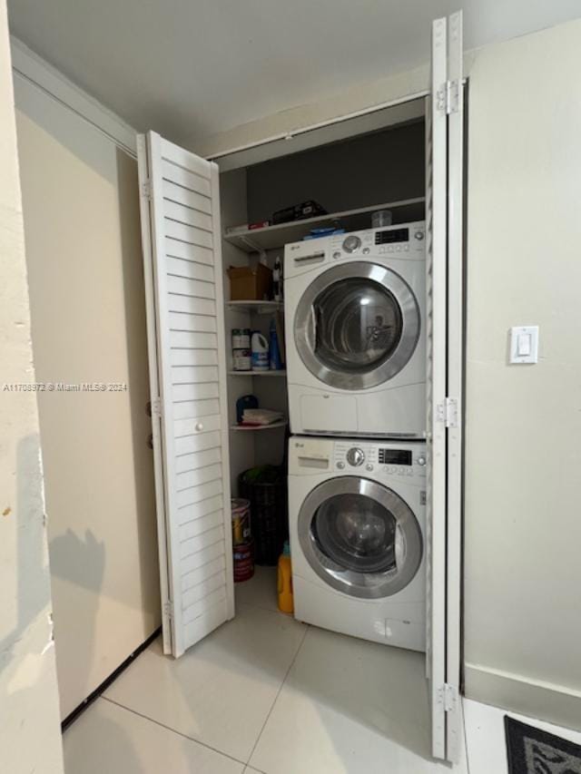 washroom featuring stacked washing maching and dryer and light tile patterned flooring