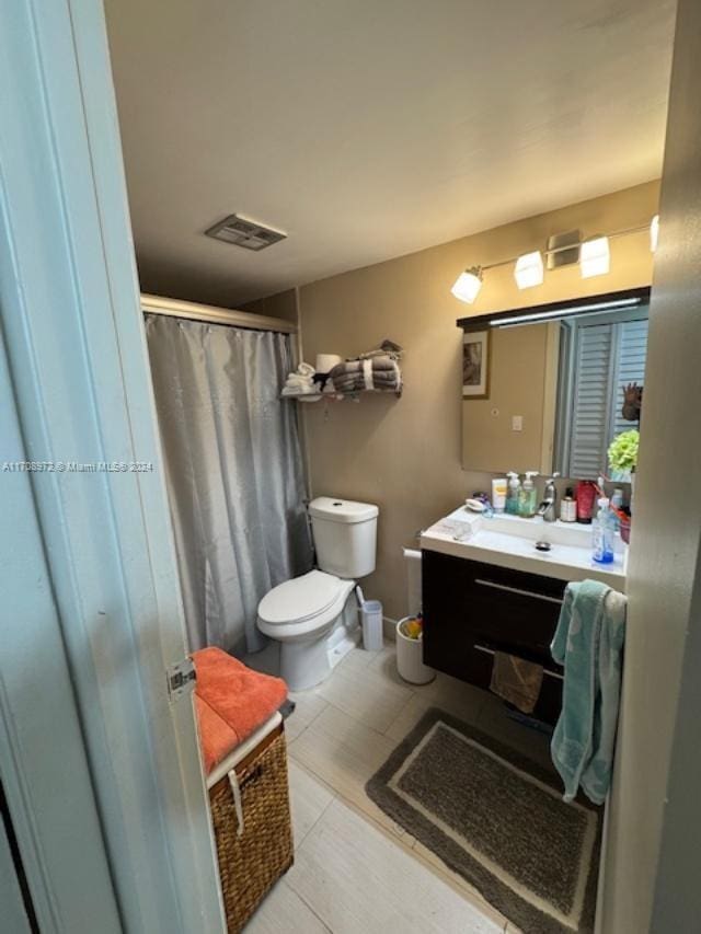 bathroom featuring tile patterned flooring, vanity, a shower with shower curtain, and toilet