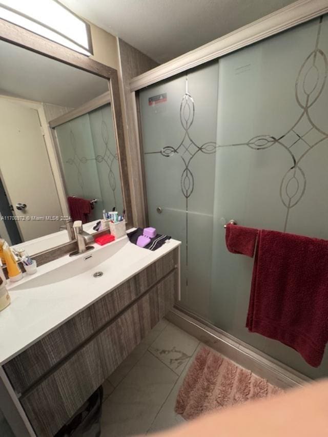 bathroom with vanity and a shower with shower door