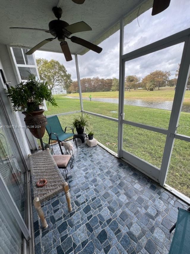 unfurnished sunroom with ceiling fan