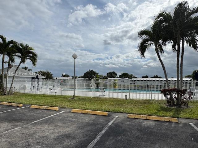 view of vehicle parking featuring a community pool