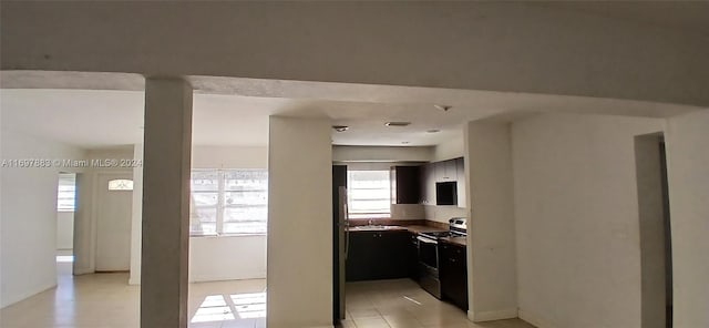 kitchen with light tile patterned flooring, sink, and electric stove