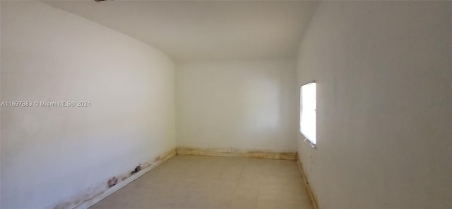 unfurnished room with vaulted ceiling