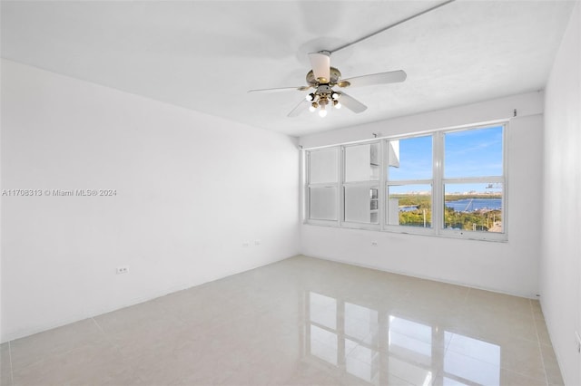 spare room featuring ceiling fan and light tile patterned floors