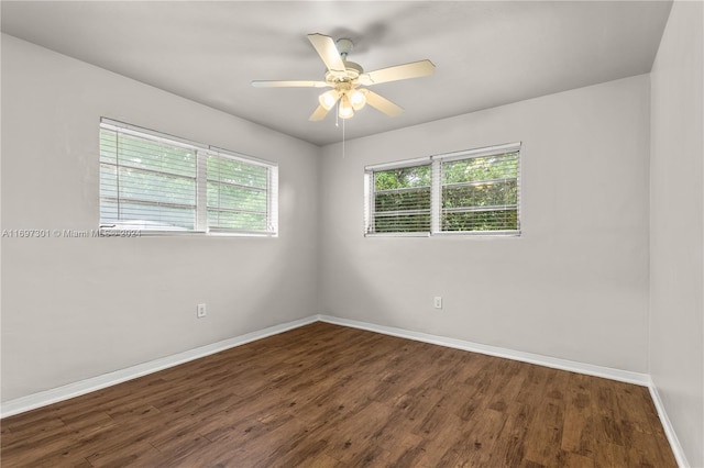 unfurnished room with ceiling fan and dark wood-type flooring