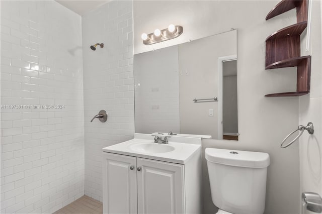 bathroom featuring tiled shower, vanity, and toilet