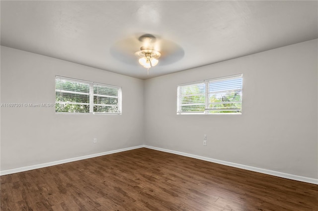 unfurnished room with dark wood-type flooring, ceiling fan, and a healthy amount of sunlight