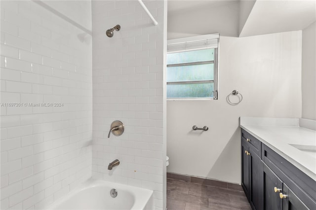 bathroom featuring vanity, wood-type flooring, and tiled shower / bath combo