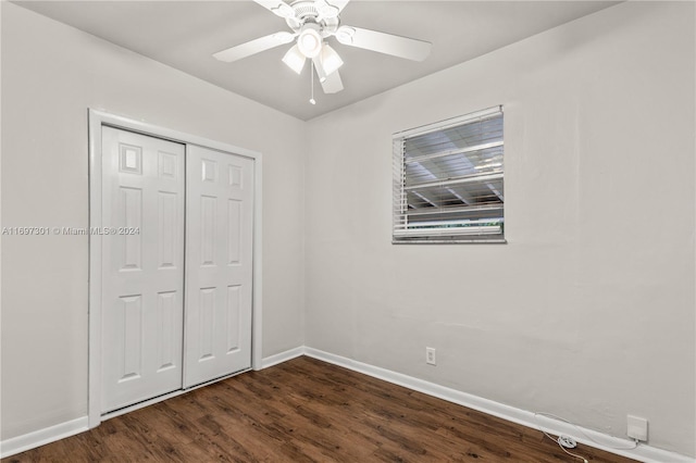 unfurnished bedroom with ceiling fan, a closet, and dark hardwood / wood-style floors