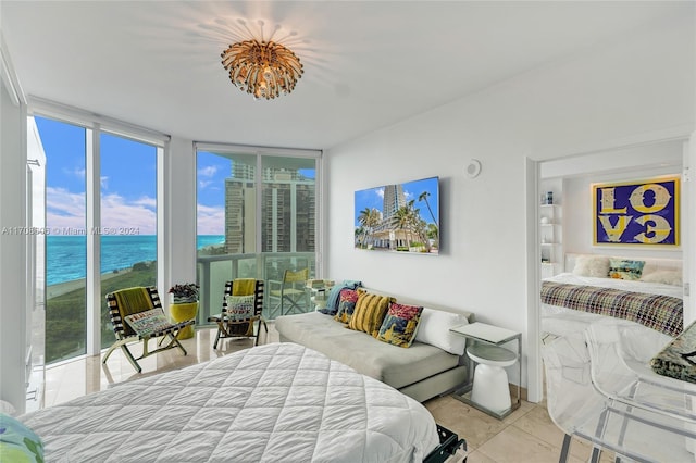 bedroom featuring access to exterior, expansive windows, a water view, and light tile patterned floors