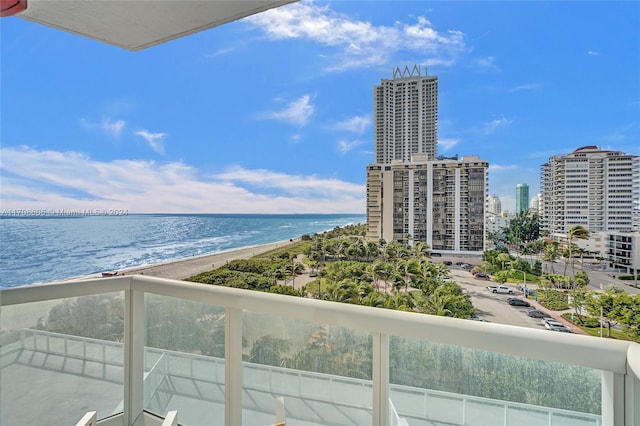 balcony with a water view and a view of the beach