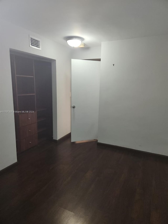 unfurnished room with dark hardwood / wood-style flooring