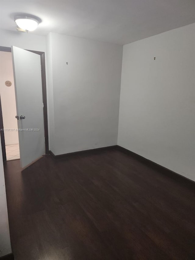 unfurnished room with dark hardwood / wood-style flooring