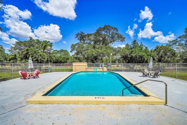 pool with fence and a patio