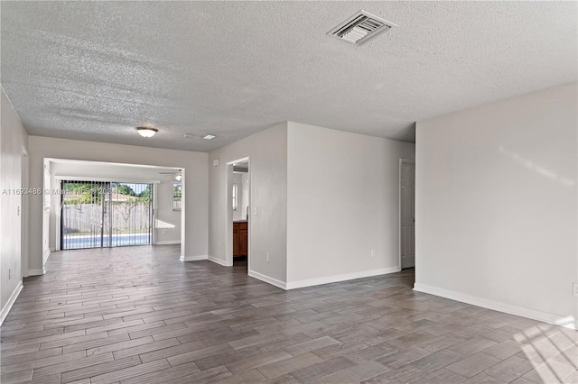 spare room with wood-type flooring and a textured ceiling