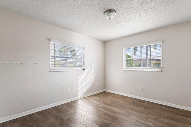 empty room featuring hardwood / wood-style floors and a textured ceiling