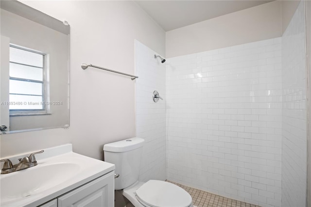 bathroom with tiled shower, tile patterned floors, vanity, and toilet