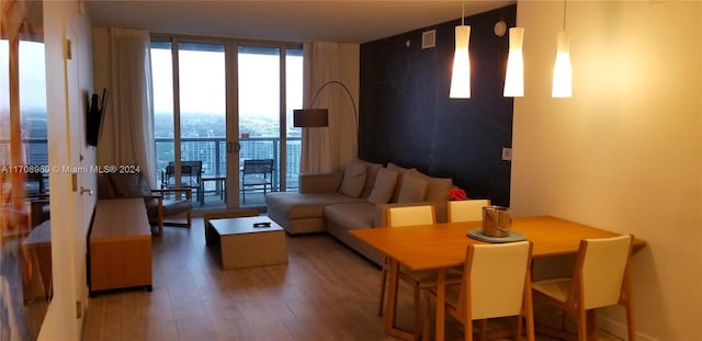 living room featuring wood-type flooring and a wall of windows