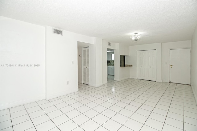 unfurnished room with light tile patterned floors and a textured ceiling