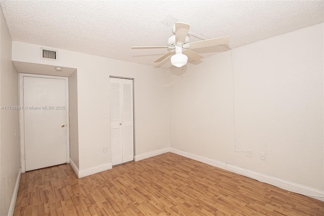 unfurnished bedroom with a textured ceiling, light hardwood / wood-style flooring, and ceiling fan