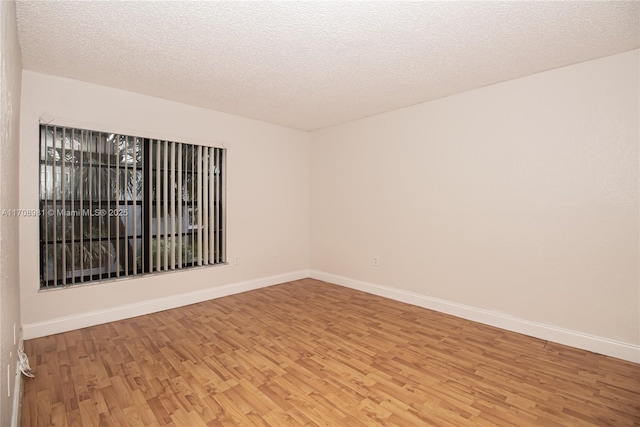 empty room featuring wood-type flooring and a textured ceiling