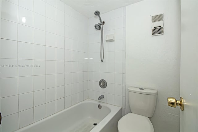 bathroom with tiled shower / bath combo and toilet