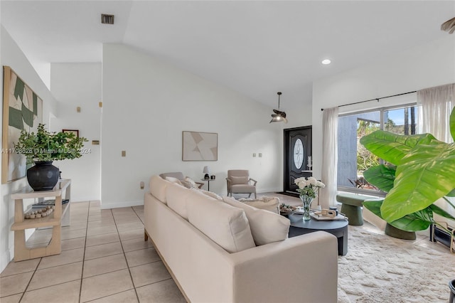 living room featuring vaulted ceiling, light tile patterned flooring, and a textured ceiling